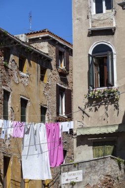 Çamaşırları kurumaya bırakılmış tipik bir Venedik evi cephesi. İşarette, en yakın Vaporetto teknesine ulaşmak için