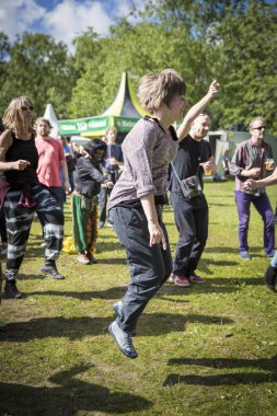 Amsterdam, Hollanda - 3 Temmuz 2016: Dünya müziği Afrikalı grup Baba Commandant ve Mandingo Band'in Amsterdam Roots Open Air'de dans eden ve zıplayan genç kadın konseri, Oosterpark'ta düzenlenen ücretsiz halk kültür festivali