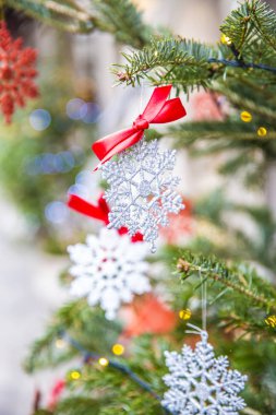 Parlak parlak kar taneleri Noel ağacında asılı duruyor.