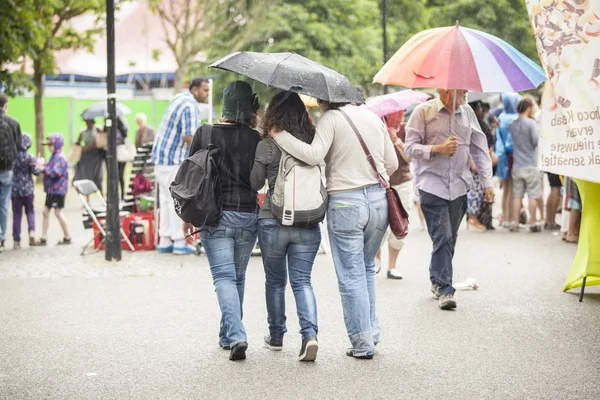 Amsterdam, The Netherlands - July, 5 2015: vistors walking under the rain during Amsterdam Roots Open Air, a cultural festival held in Park Frankendael on 05/07/2015