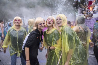 Amsterdam, Hollanda - 29 Temmuz 2017: Westerpark'taki Milkshake Festivali'nde yağmur ponçolarıyla yağmur altında dans eden insanlar