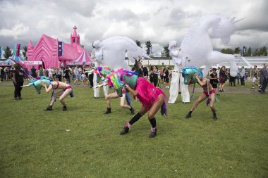 Amsterdam, Hollanda - 30 Temmuz 2017: Renkli tek boynuzlu atlar gibi giyinmiş dansçılar ve bazıları büyük şişme beyaz tek boynuzlu at kostümlü Westerpark Milkshake Festivali'nde sahne alıyor