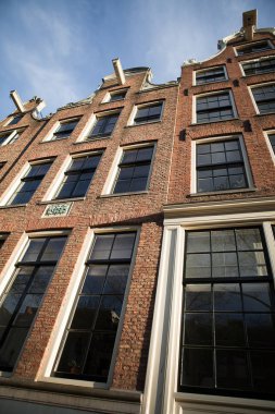 Amsterdam, tipik bir tarihi kanal evinin önünde