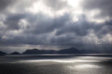Adriyatik denizi, tepeler ve gri bulutlar ile dramatik gökyüzü ile bir ada manzaralı Hırvatistan sahil manzara