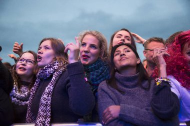Traena, Norveç - 08 Temmuz 2016: Norveçli folk ve rock grubu Violet Road'un Traenafestival'deki konserinde seyirciler tezahürat yapıyor, Norveç'in küçük Traena adasında müzik festivali düzenleniyor