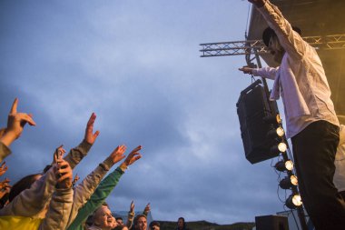 Traena, Norveç - 9 Temmuz 2015: İsveçli rock grubu Movits'in hava konserinde seyirciler tezahürat yapıyor, alkışlıyor! Traenafestival, müzik festivali Traena küçük adada yer alan