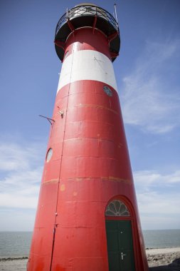 Mavi gökyüzü arka plan üzerinde kırmızı ve beyaz deniz feneri, Westkapelle, Hollanda