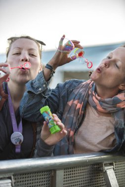 Traena, Norveç - 12 Temmuz 2014: İzlandalı şarkıcı Mugison'un Traenafestival'deki konseri sırasında baloncuk yaparken eğlenen genç kadınlar, traena adasında düzenlenen müzik festivali