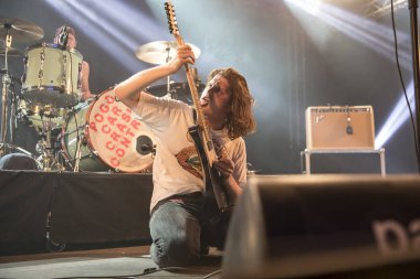 Nyon, İsviçre - 20 Temmuz 2017: Fransız Punk Grunge rock grubu Pogo Car Crash Control'ün Paleo Festivali'nde verdiği konser, gitarist gitarını yalarken yerde