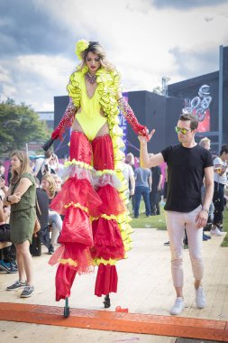 Amsterdam, Hollanda - 30 Temmuz 2017: Westerpark Milkshake Festivali'nde ayaklıklar üzerinde yürüyen renkli kırmızı ve sarı kostümlü drag queen