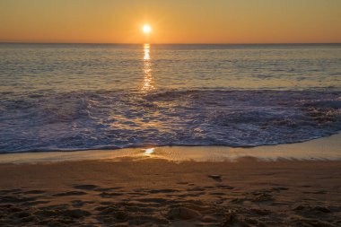 Kışın denizin üzerinde büyülü ve romantik bir gün batımı