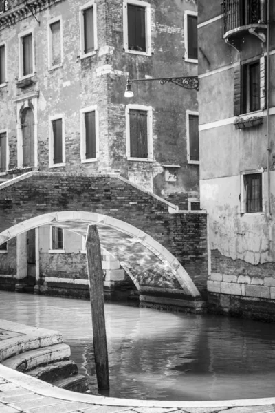 Black and white photo of a small bridge over a canal, Venice, Italy