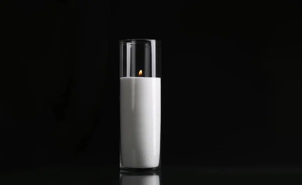 glass candlestick with a candle isolated on a black background