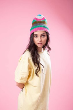 Güzel ve genç birbayan sarı top ekşitmeden kamera için poz çevresinde kandırıyor. Stüdyo portre pembe bir arka plan üzerinde.