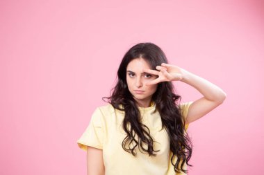 Prenses ve burada bir numara benim! Oldukça sevimli stüdyo fotoğraf portre yakından coquet heyecanlı Bayan sizi izole kamera parlak renk pastel vasıl geçmiş baktığını yakınındaki v-sign yapma büyüleyici