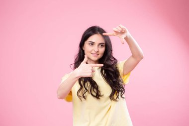 Güzel ve genç birbayan sarı top ekşitmeden kamera için poz çevresinde kandırıyor. Stüdyo portre pembe bir arka plan üzerinde.