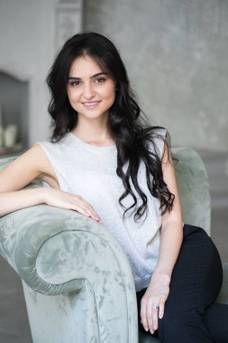 Çekici esmer işkadını gri koltukta oturan 