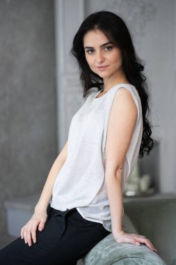 Çekici esmer işkadını gri koltukta oturan 