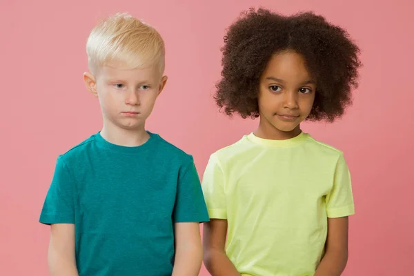 小さな子供たちのサイドビュー 幸せなカップルの白人と混合人種の子供たちが近くに座っています ピンクの背景に隔離された — ストック写真