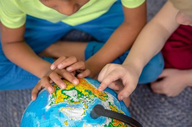 Sınıftaki dünyayı gösteren küçük çocukların yan görüntüsü. Pembe arka planda izole edilmiş iki mutlu çocuk.