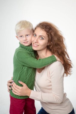 Açık gri arka planda çocuğu olan mutlu genç bir anne.