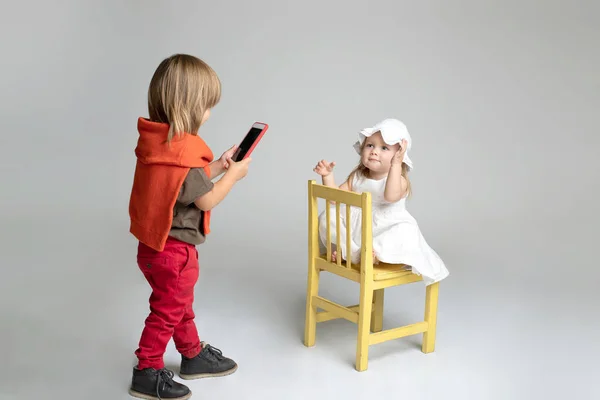 Мальчик Лет Фотографирует Ребенка Используя Смартфон Девушка Забавно Позирует Ему — стоковое фото