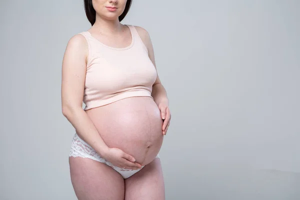 Çamaşırlı Hamile Beyaz Kadın Beyaz Bir Arka Planda Stüdyo Fotoğrafı — Stok fotoğraf