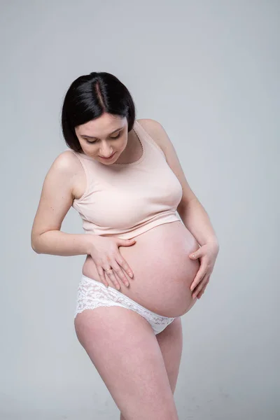 Ciężarna Młoda Brunetka Bieliźnie Emocjonalne Zdjęcie Studyjne Ciąży Białym Tle — Zdjęcie stockowe