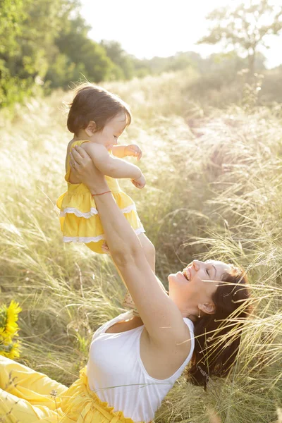 Mom Little Daughter Plays Grass Meadow Child Raised Sun Beautifully — Stock Photo, Image