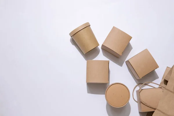 Cardboard containers and a bag for food, drinks and objects. White background. Isolate Top view. Copy space. Delivery concept, takeaway, craft packaging.