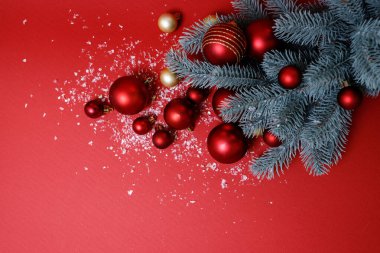 Kırmızı ve yeşil yılbaşı arkaplanı. Şenlikli dekoratif kompozisyon Noel ağacı, büyük ve küçük kırmızı ve altın toplar, yapay kar. Üst Manzara. Hiç kimse. Yatay, mesaj için yer. Mutlu yıllar teması