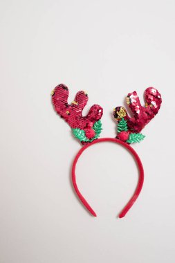 Geleneksel saç aksesuarı: bej arka planda Noel geyiği boynuzları. Parıltılarla süslenmiş. Mutlu Noeller. Şık bir yeni yıl kartı. Uzayı kopyala Yatay.