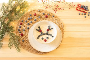 Çocuk mamaları için yaratıcı Noel dekorasyonu kavramı, sağlıklı çocuk yemekleri. Boynuzlu bir geyik yüzü taze ahududu ve yaban mersininden yapılmıştır..