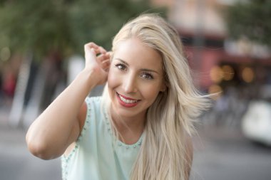 Çekici sarışın kadın kameraya bakıyor ve mutlu poz