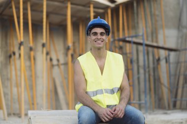 Kameraya bakarak dinlenen inşaat işçisi