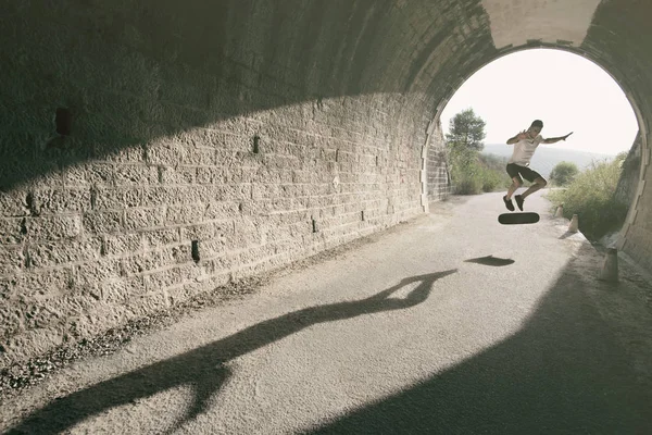 Ung Man Tunnel Med Skateboard Hoppa Vidvinkel Bild — Stockfoto