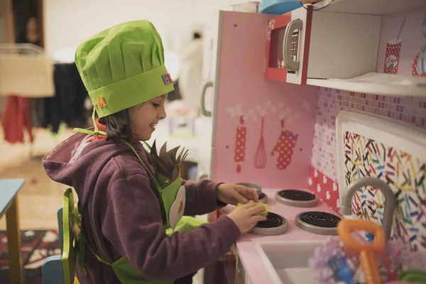 küçük kız oyuncak mutfakta oynuyor