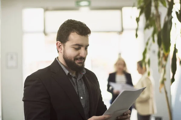 Skäggiga kostym man poserar i office arbetsplatsen — Stockfoto