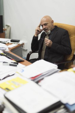 Olgun ve zarif adam stresli veya belgelerin büyük birikimi ile iş sırasında hasta