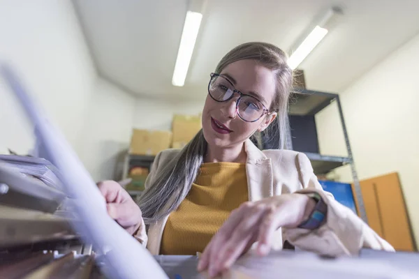 wide angle of attractive office woman working looking files in basement