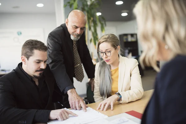 ofiste farklı çalışma ekibi tabloda dosyaları arıyor