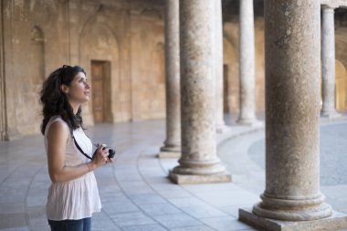 Güneşli bir günde La Alhambra 'ya fotoğraf çeken bir turist kadın. Carlos V Sarayı