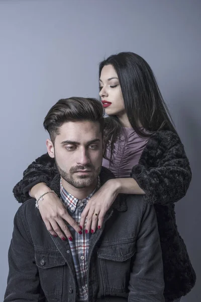 Young attractive couple in studio shot posing