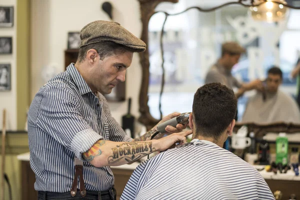 Barbier, homme coupe les cheveux de la personne — Photo
