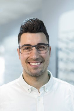 Yakışıklı adam optik göz mağazasında gözlük çalışıyor
