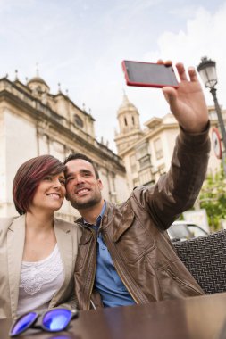  Akıllı telefon ortam ışığı ile selfie çekerek açık hava bar terasında çift