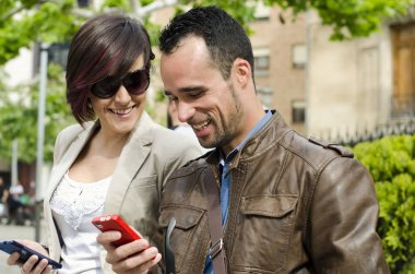 Çift gülümseyen ve rahat görüntü şehirde telefon dokunmadan