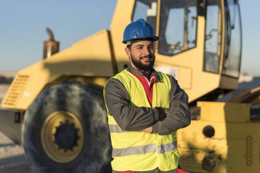Sakallı inşaat işçisi buhar rulo makinesine ner poz