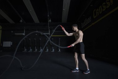 Genç adam iple sağlık kulübünde eğitim görüyor.