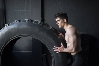 Ağır tekerlek ile spor salonunda Adam eğitimi